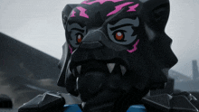 a close up of a black toy with a pink stripe on the face