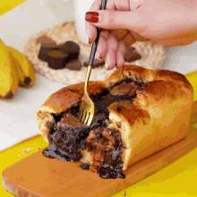 a person is taking a bite out of a loaf of bread