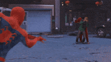 a man in a red jacket and a black mask is holding a spider web