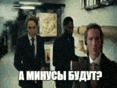 a group of men in suits and ties are walking down a hallway . one of the men is wearing headphones .