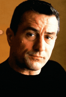 a close up of a man 's face with a black shirt