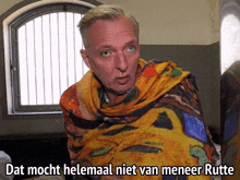 a man wrapped in a colorful blanket with the words dat mocht helemaal niet van meneer rotte above him