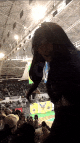 a woman stands in a stadium with a play button on the bottom right