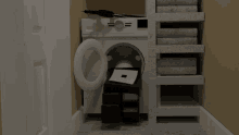 a washer and dryer in a closet with a stack of towels behind it