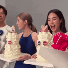 a woman in a blue dress is holding a cake that says ' nivea ' on it