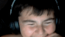 a young boy wearing headphones is making a face