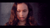 a close up of a woman 's face with a serious look on her face