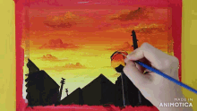 a person is painting a sunset with a brush on a piece of paper
