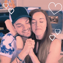 a man and a woman are hugging with hearts surrounding them