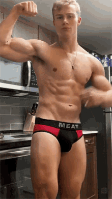 a shirtless man in underwear that says meat on it