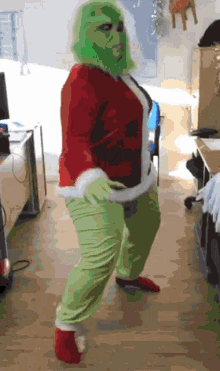 a woman in a grinch costume is dancing
