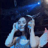 a woman wearing headphones and a shirt that says " my baby "