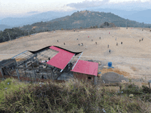 a group of people are playing soccer on a field with a mountain in the background