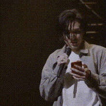 a man holding a microphone and a cell phone