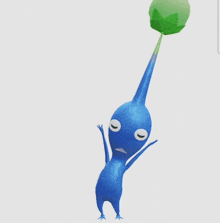 a blue cartoon character is holding a green leaf
