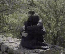 a black and white photo of two people hugging