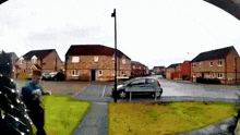 a car is parked on the side of the road in a neighborhood