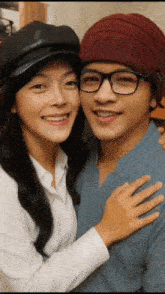 a man and a woman are posing for a picture and the man is wearing glasses
