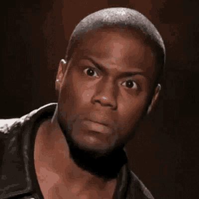 a close up of a man making a funny face with his eyes wide open .