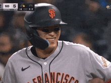 a baseball player wearing a san francisco jersey smiles