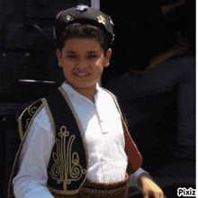 a young boy wearing a black hat and a white shirt is smiling for the camera