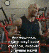 a man in a black tank top is standing in a gym with a clock on the wall above him