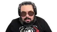 a man with a beard wearing headphones and sunglasses is making a funny face .