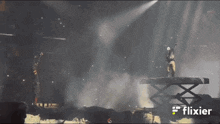 two men standing on a stage with a flixier logo in the corner