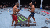 two men are fighting in a boxing ring with a monster energy drink advertisement in the background