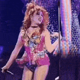 a woman with red hair is singing into a microphone on a stage .