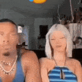 a man and a woman are sitting next to each other in a room .