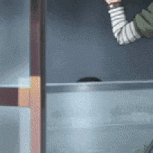 a person with a striped arm is standing in front of a fridge .