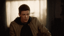 a man wearing a brown jacket and black hoodie