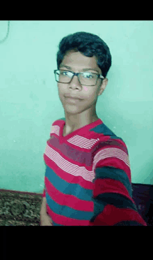 a young man wearing glasses and a red and blue striped shirt