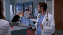 a doctor wearing a white coat and a stethoscope is talking to another doctor