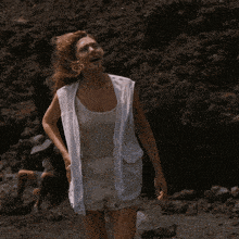 a woman in a white tank top and white vest