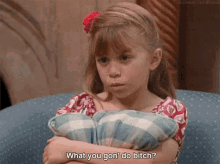 a little girl with her arms crossed is holding a pillow and saying what you gon do bitch