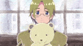 a man with glasses is holding a teddy bear in his hands .