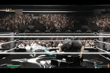 a man is laying on the ground in a wrestling ring while a referee watches .
