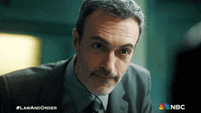 a man in a suit and tie is looking at the camera with a nbc logo in the corner