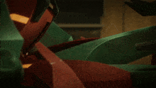 a green robot with a red helmet is looking down