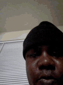 a close up of a person 's face with a striped wall in the background