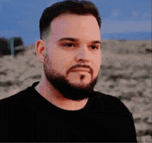 a man with a beard and mustache wearing a black shirt