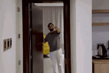 a man with a beard is standing in a doorway in a hotel room .