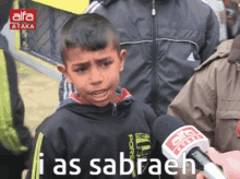 a boy talking into a microphone with the words i as sabraeh written on the bottom
