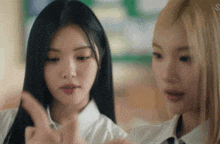 two girls are looking at something and one is pointing at something