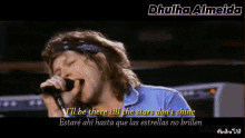 a man singing into a microphone with the words " i 'll be there till the stars don 't shine " in yellow