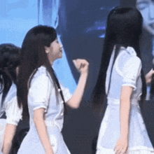 a group of young women are standing next to each other and one of them is holding another woman 's hand .