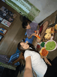a man and a woman are sitting on the floor with food