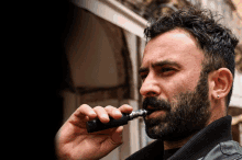 a man with a beard is smoking a cigarette